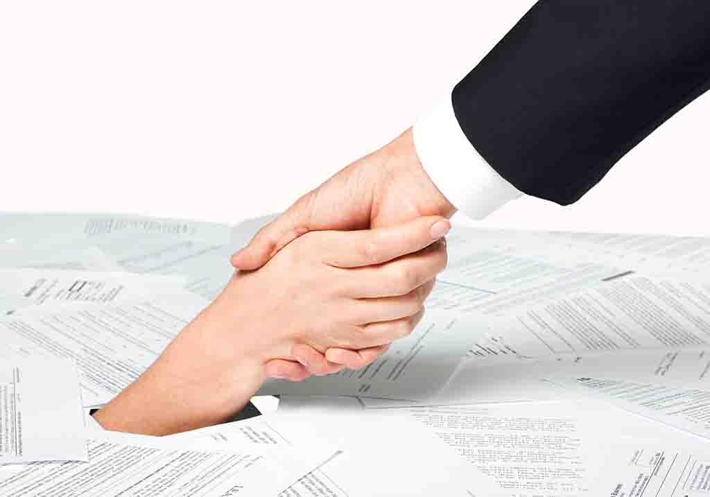 a helping hand pulling another out of a pile of bills